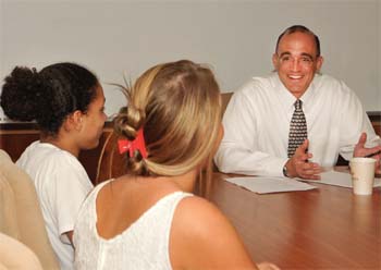 New St. Mary’s High School Principal Mark DiFabio interacts with students Brianna Rudolph, left, and Garbiele Ayers, at the school.