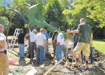 Ward 2 City Councilor Bill Trahant Jr. (third from left, back to camera) oversees the playground equipment installation project at the Henry Avenue Playground. At far right is Lynn Classical student Damien Earp, one of the volunteers.