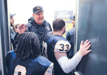 Coach Matt Durgan celebrates his 150th victory and ushers his team into the locker room for a post game talk.